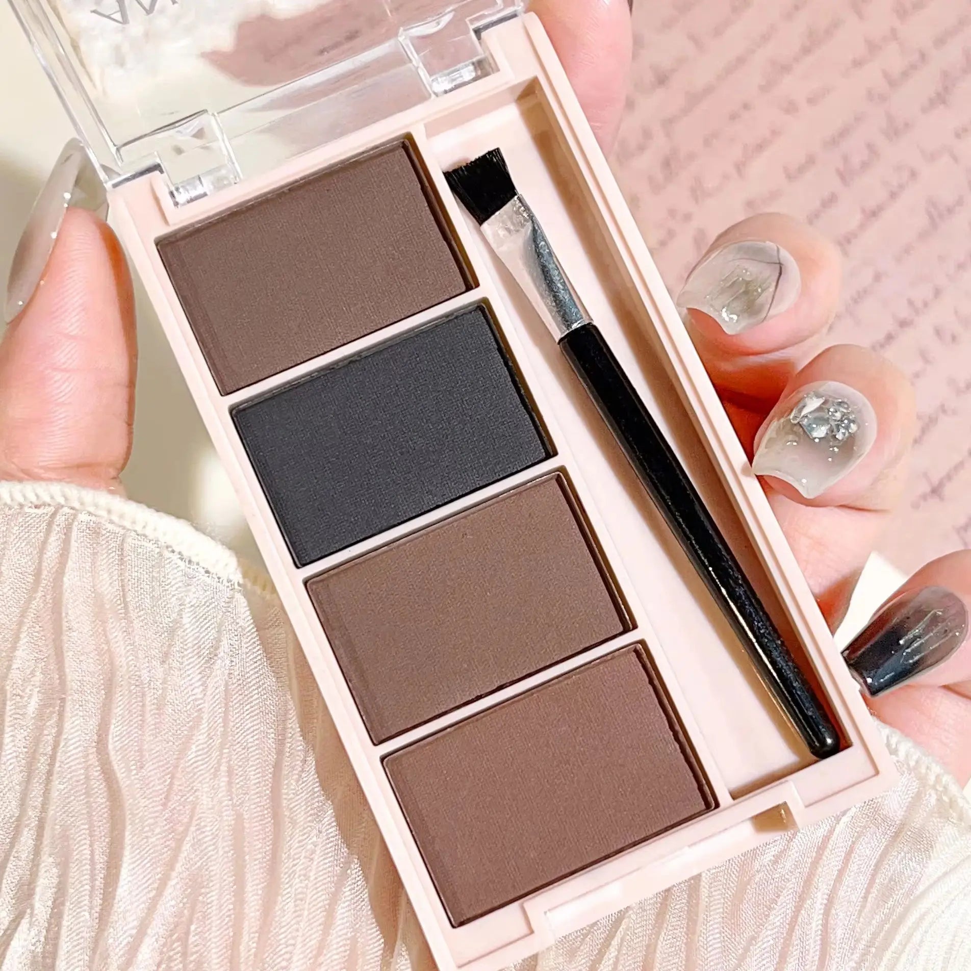 Eyebrow powder trays with brushes in gray and brown matte tones for long-lasting color.