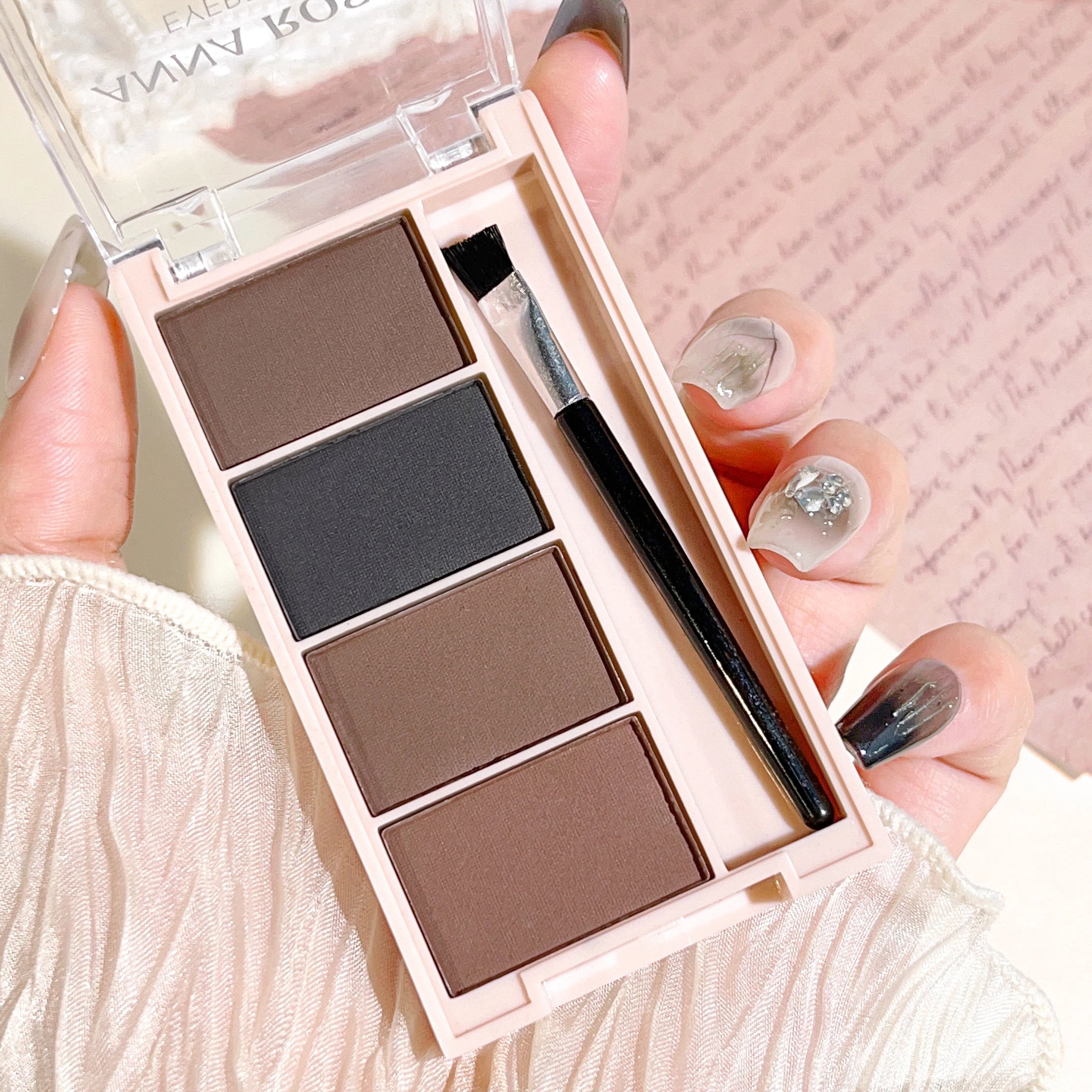Eyebrow powder trays with brushes in gray and brown matte tones for long-lasting color.