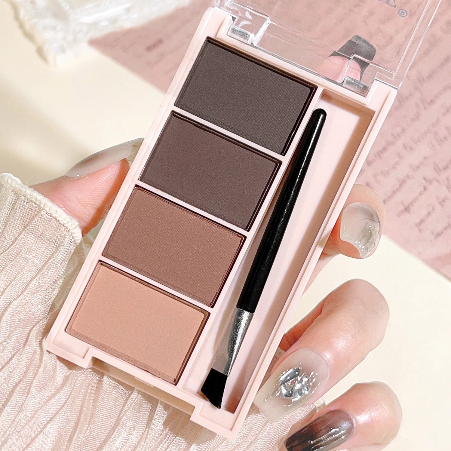Eyebrow powder trays with brushes in gray and brown matte tones for long-lasting color.