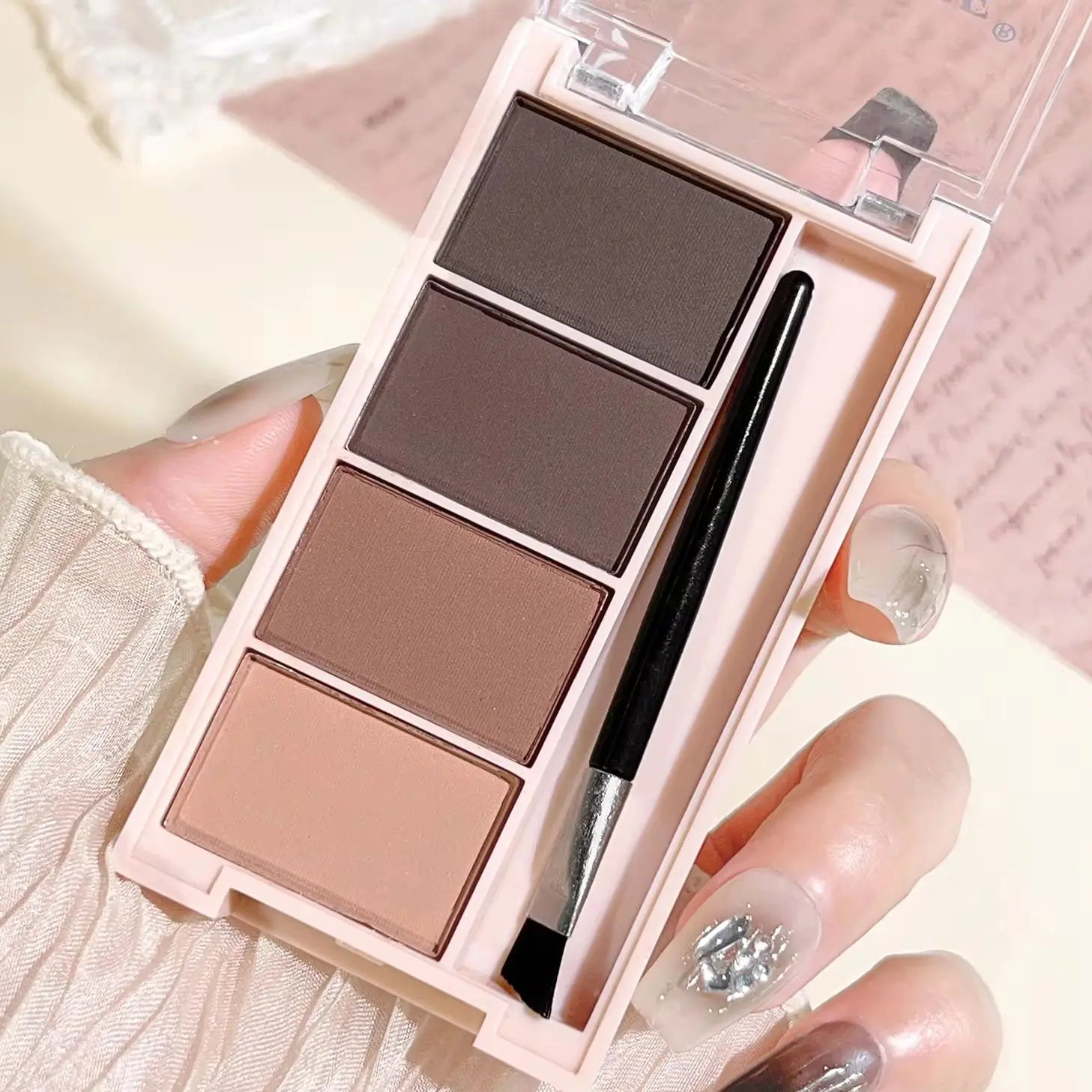 Eyebrow powder trays with brushes in gray and brown matte tones for long-lasting color.