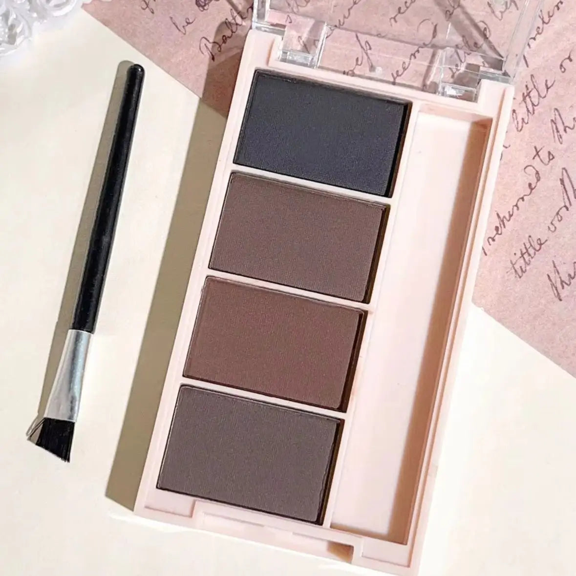 Eyebrow powder trays with brushes in gray and brown matte tones for long-lasting color.