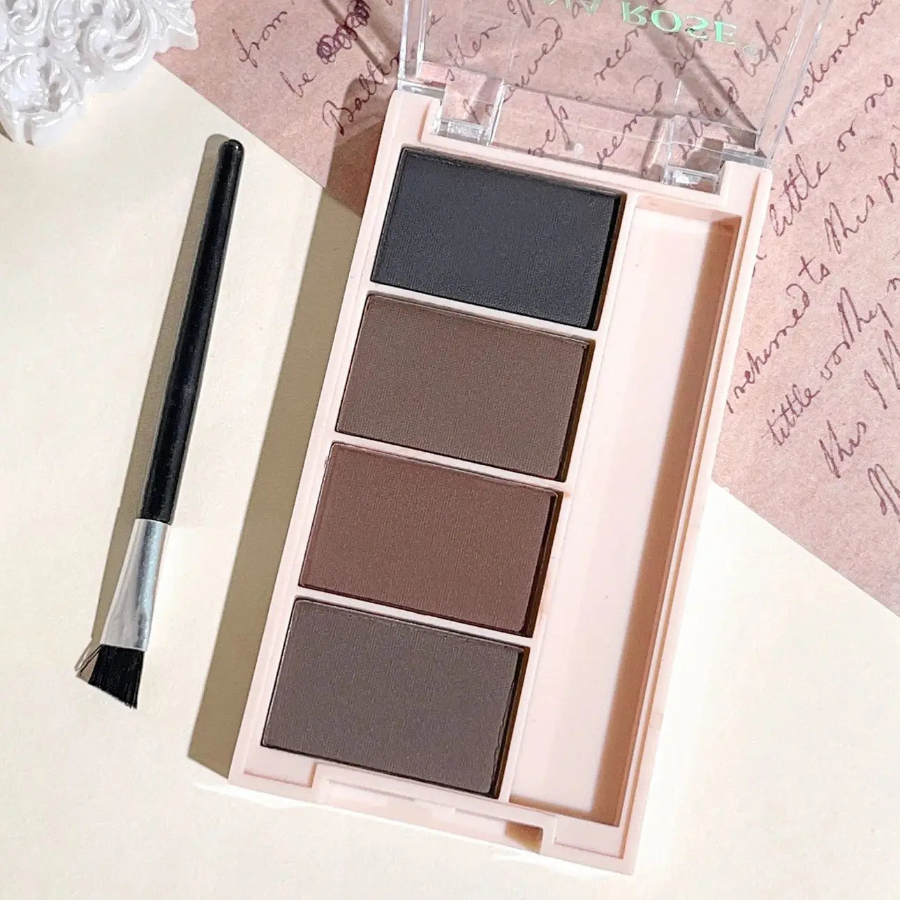Eyebrow powder trays with brushes in gray and brown matte tones for long-lasting color.