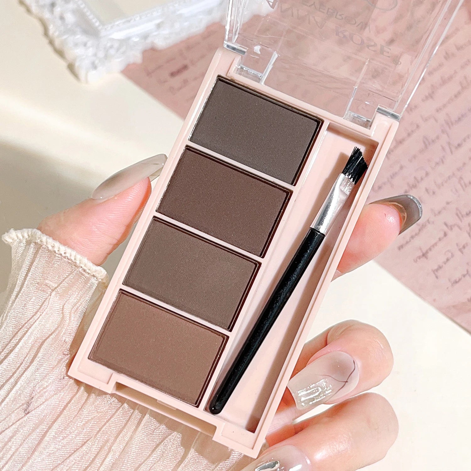 Eyebrow powder trays with brushes in gray and brown matte tones for long-lasting color.