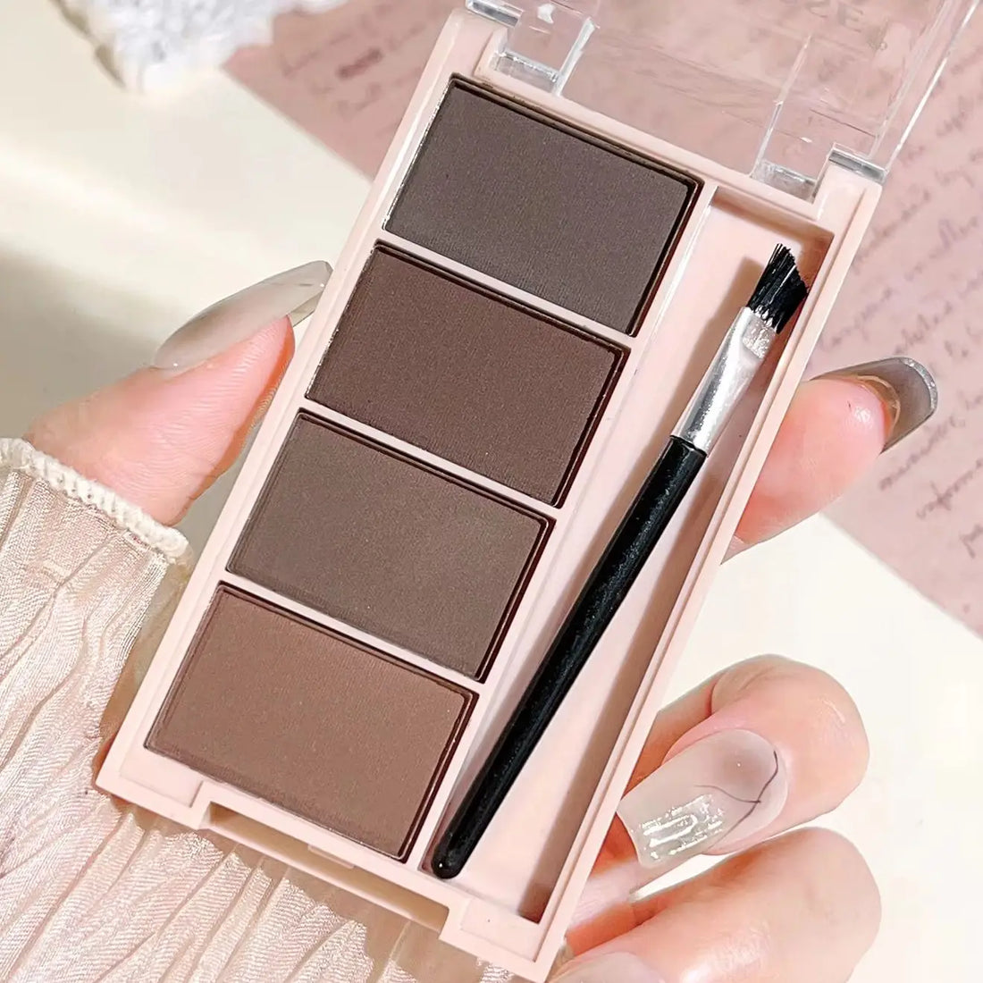 Eyebrow powder trays with brushes in gray and brown matte tones for long-lasting color.
